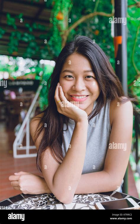 Cute Asian Thai Women Portrait Sitting In The Cafe Relax Posture With Dental Lovely Smile Stock