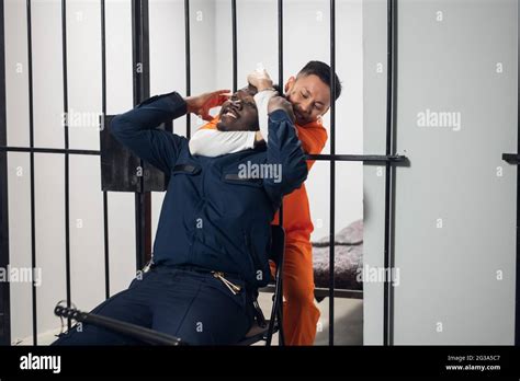 A Crazy Prison Inmate Strangles A Black Warden Through The Bars Of A