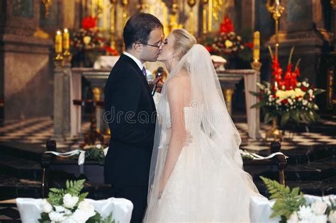 Newlywed Bride And Groom First Kiss At Wedding Ceremony In Churc Stock