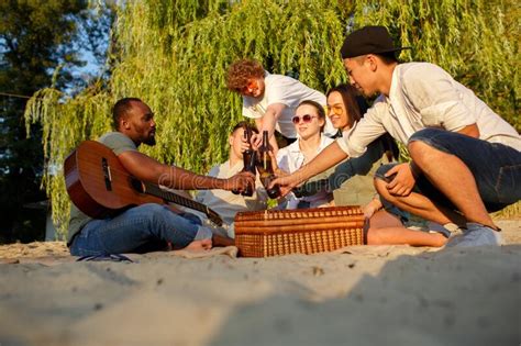 Group Of Friends Clinking Beer Glasses During Picnic At The Beach Lifestyle Friendship Having