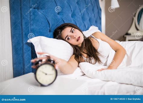Wake Up Of An Sleep Girl Stopping Alarm Clock On The Bed In The Morning