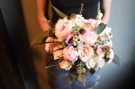 bridal bouquet featuring peonies roses spray roses eucalyptus and scabiosa seed pods rustic