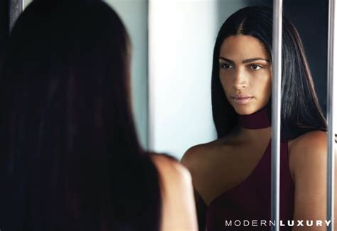 A Woman Looking At Herself In The Mirror With Her Long Dark Hair And Brown Eyes