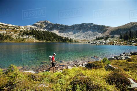 A Ultralight Backpacker Hikes Along The Shore Of Valentine Lake Near