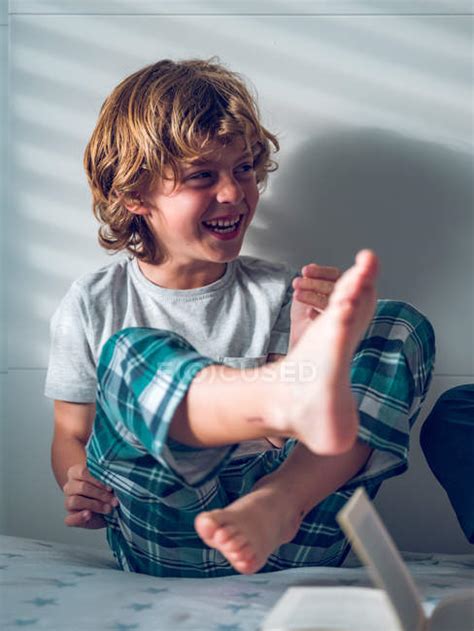 Boy In Pajamas Sitting On Bed — Barefoot Leisure Stock Photo