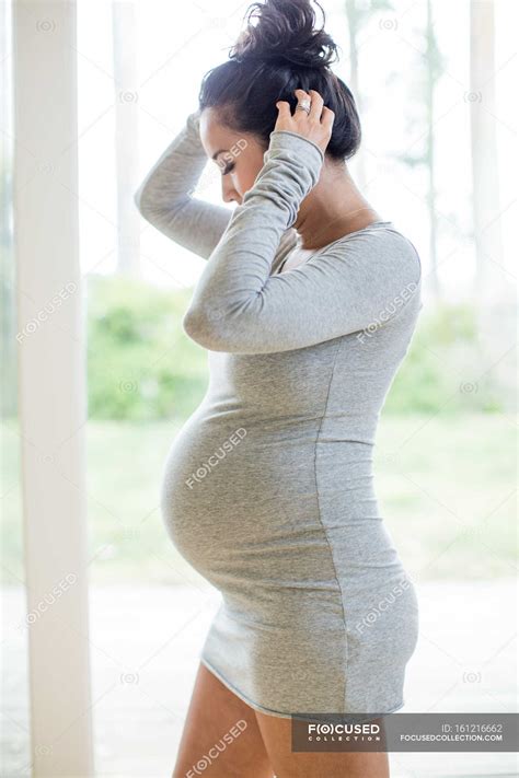 Pregnant Woman Wearing Tight Dress To Years Touching Stock