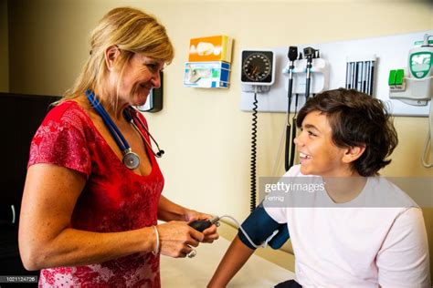 A Female Doctor Checking A Childs Blood Pressure High Res Stock Photo