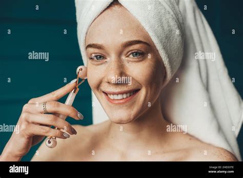 Close Up Portrait Of A Woman Getting Massage Face Using Jade Facial Roller For Skin Care Facial