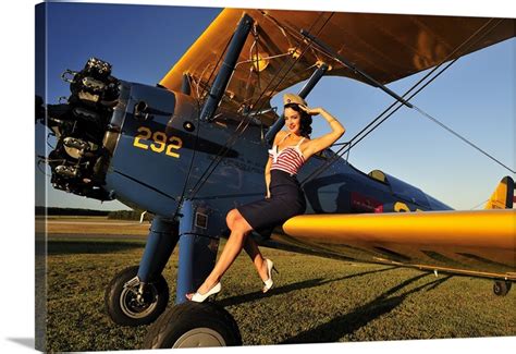 1940s Style Pin Up Girl Sitting On The Wing Of A Stearman Biplane Wall