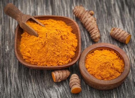 Premium Photo Raw Turmeric With Powder In Wooden Bowl