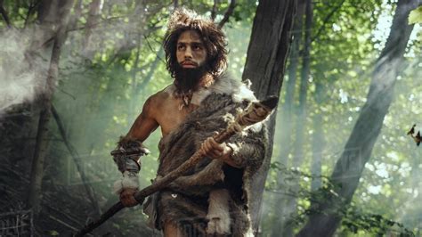Portrait Of Primeval Caveman Wearing Animal Skin And Fur Hunting With A