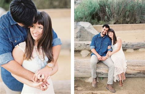 A Man And Woman Sitting On A Log In The Sand With Their Arms Around