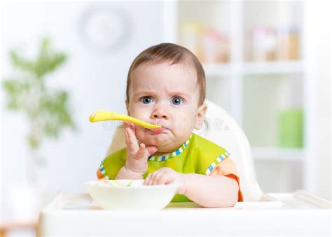 Funny Baby Eating Food On Kitchen Stock Image Image Of Kitchen Home