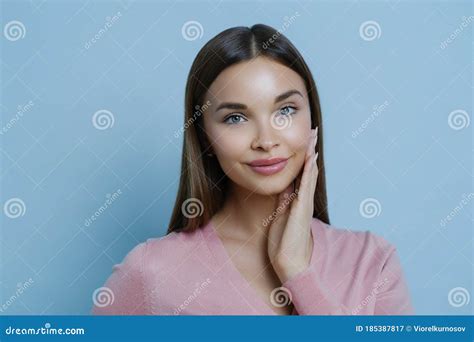 Photo Of Adorable Young Millennial Female Touches Cheek Gently Enjoys