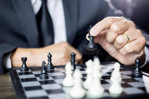 Hand Of Businessman Moving Chess Figure In Competition Board Game For