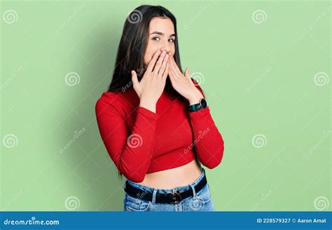 Young Brunette Teenager Wearing Red Turtleneck Sweater Laughing And Embarrassed Giggle Covering