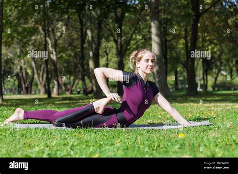 Young Slender Pretty Woman Practice Hatha Yoga And Stretching In Summer