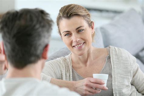 Mature Couple Talking To Eachother At Home And Drinking Coffee Stock
