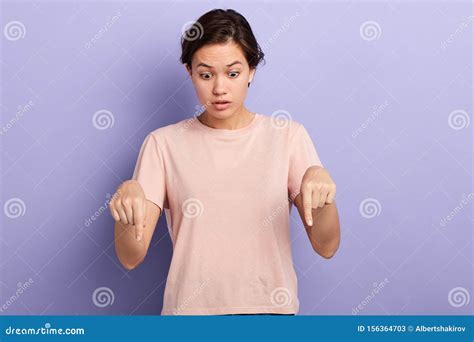 Beautiful Emotional Girl Pointing Down With Fingers Showing