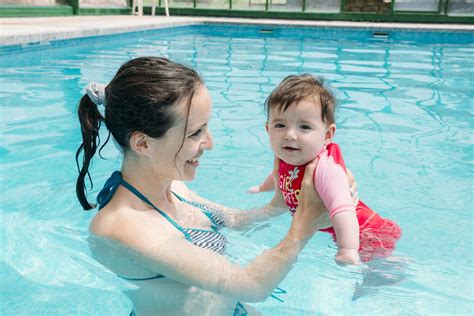 Cute Baby Girl Learning To Swim In The Pool With Her Mother Stock Photo