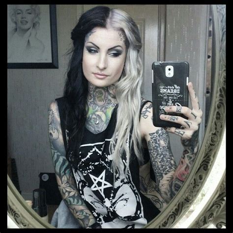 A Woman Taking A Selfie In Front Of A Mirror With Tattoos On Her Arms