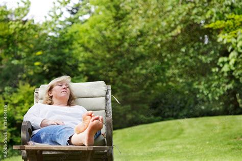 Mature Woman Dozing With Her Feet Up In A Garden Chair Foto De Stock Adobe Stock