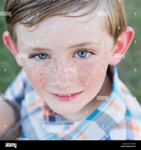 Portrait Of A Young Boy With Blue Eyes And Freckles On His Nose Stock