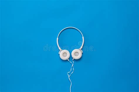 Beautiful White Headphones With A Wire On A Blue Background Stock