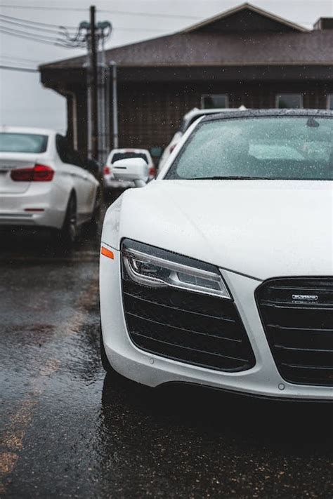 Modern White Car On Road Near House In Rainy Weather · Free Stock Photo
