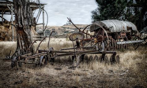 A Rusty Farm Machines On The Brown Grass Field · Free Stock Photo
