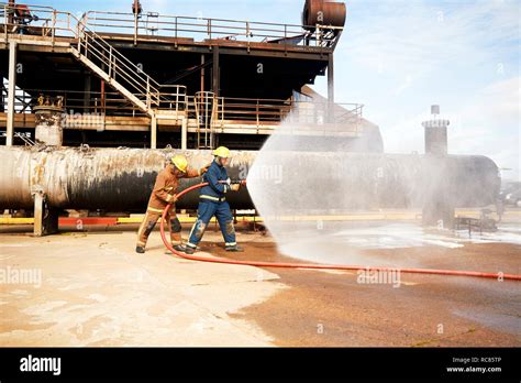 Firemen Spraying Water From Fire Hose At Training Facility Hi Res Stock
