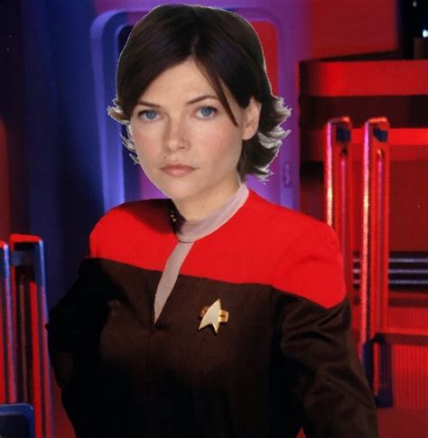 a woman in a star trek uniform is looking at the camera