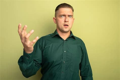 Free Photo Young Handsome Man In Green Shirt Being Confused And
