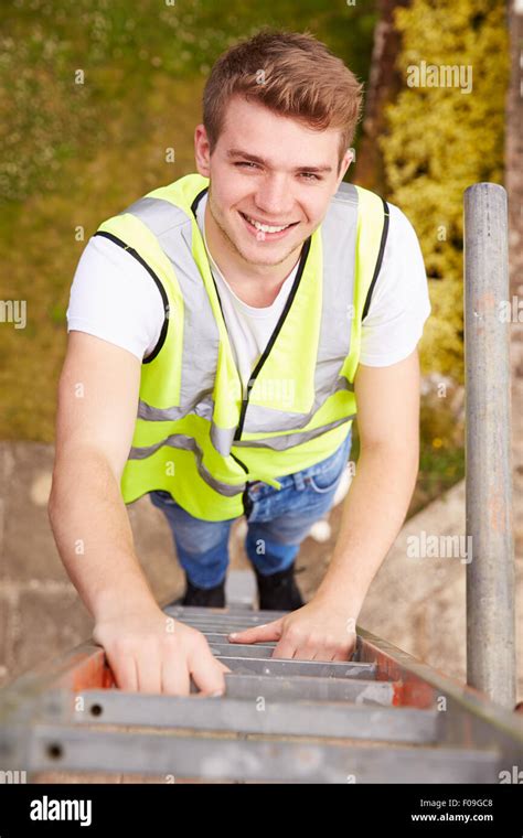 Construction Worker Climbing Ladder On Building Site Stock Photo Alamy