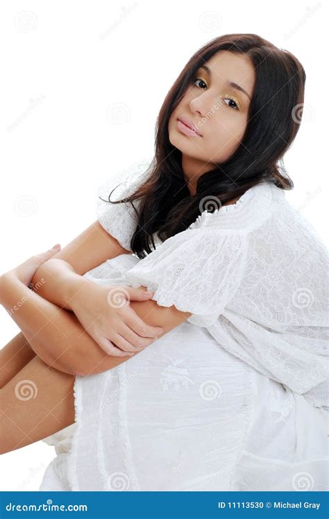 Young Hispanic Woman Sitting With Arms On Her Legs Stock Photo Image