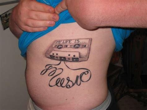 A Man With A Tattoo On His Stomach That Says Life Is Music And An Old