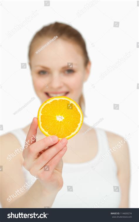 Woman Presenting Orange Slice While Smiling Stock Photo 114609274