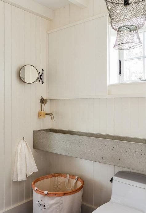 A Cottage Bathroom With A Long Concrete Trough Sink Surrounding Shiplap