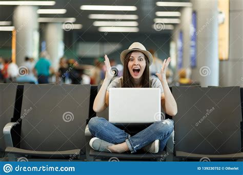 Young Shocked Traveler Tourist Woman With Laptop With Crossed Legs