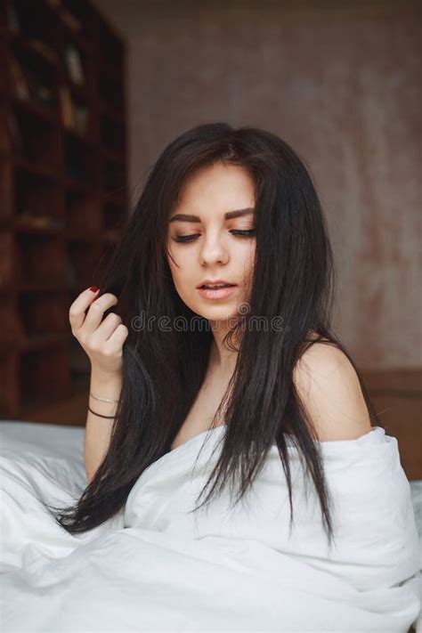 Sensual Woman With Dark Hair Sitting On A Bed Stock Photo Image Of