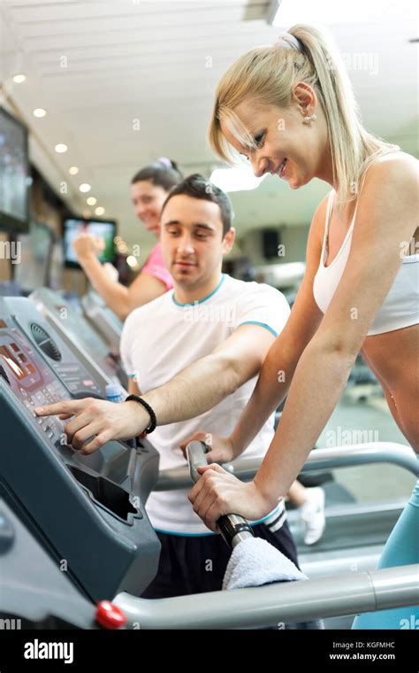 Personal Trainer Instructing Woman How To Use Treadmill Stock Photo Alamy