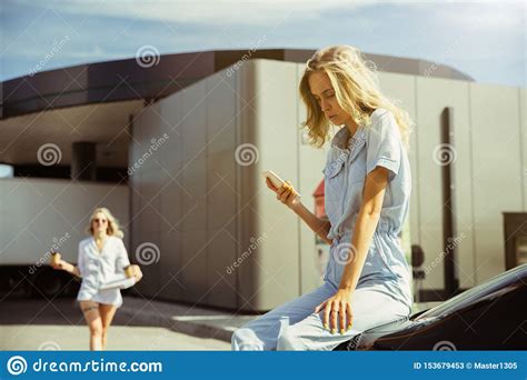 Young Lesbian`s Couple Preparing For Vacation Trip On The Car In Sunny