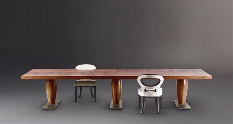 It has a smooth, gray laminate top and black metal, open frame legs. Promemoria | Bassano: Dining Table in Wood or Bronze