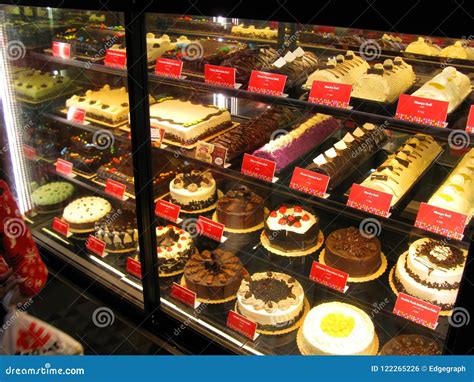 Assorted Cakes Topped With Fruit Displayed Behind Glass Supermarket