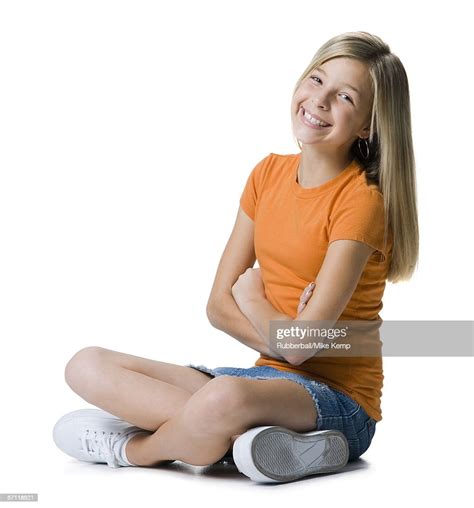 Portrait Of A Girl Sitting Crosslegged On The Floor And Smiling High