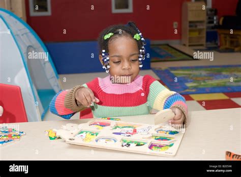 4 Year Old African American Pre School Girl Sitting At A Table Doing A