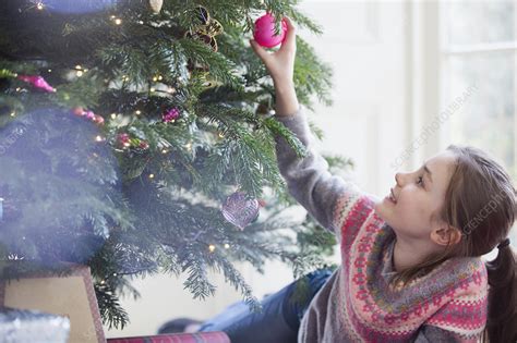 Curious Girl Touching Ornament On Christmas Tree Stock Image F022