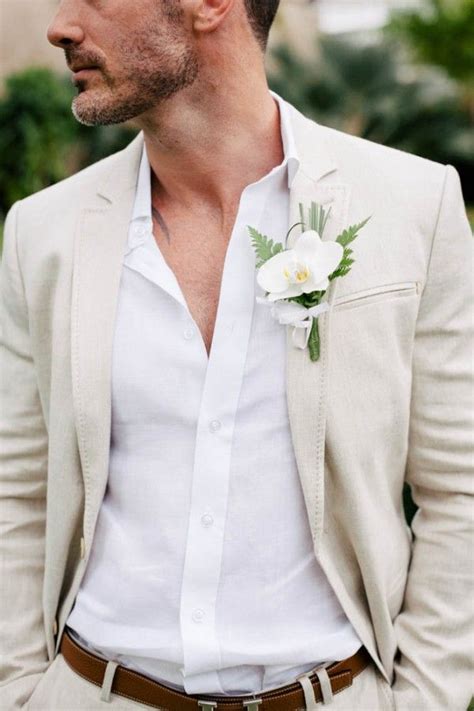 A Man In A Suit With A Boutonniere And White Flowers On His Lapel