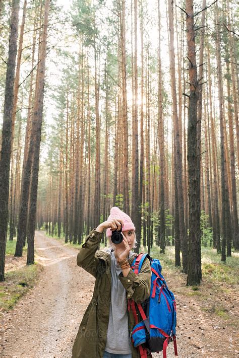 Girl In Pink Hat Taking Photo With Camera In Forest By Stocksy