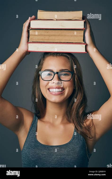 Anatomy Of A Bookworm Studio Shot Of A Young Woman Holding A Pile Of